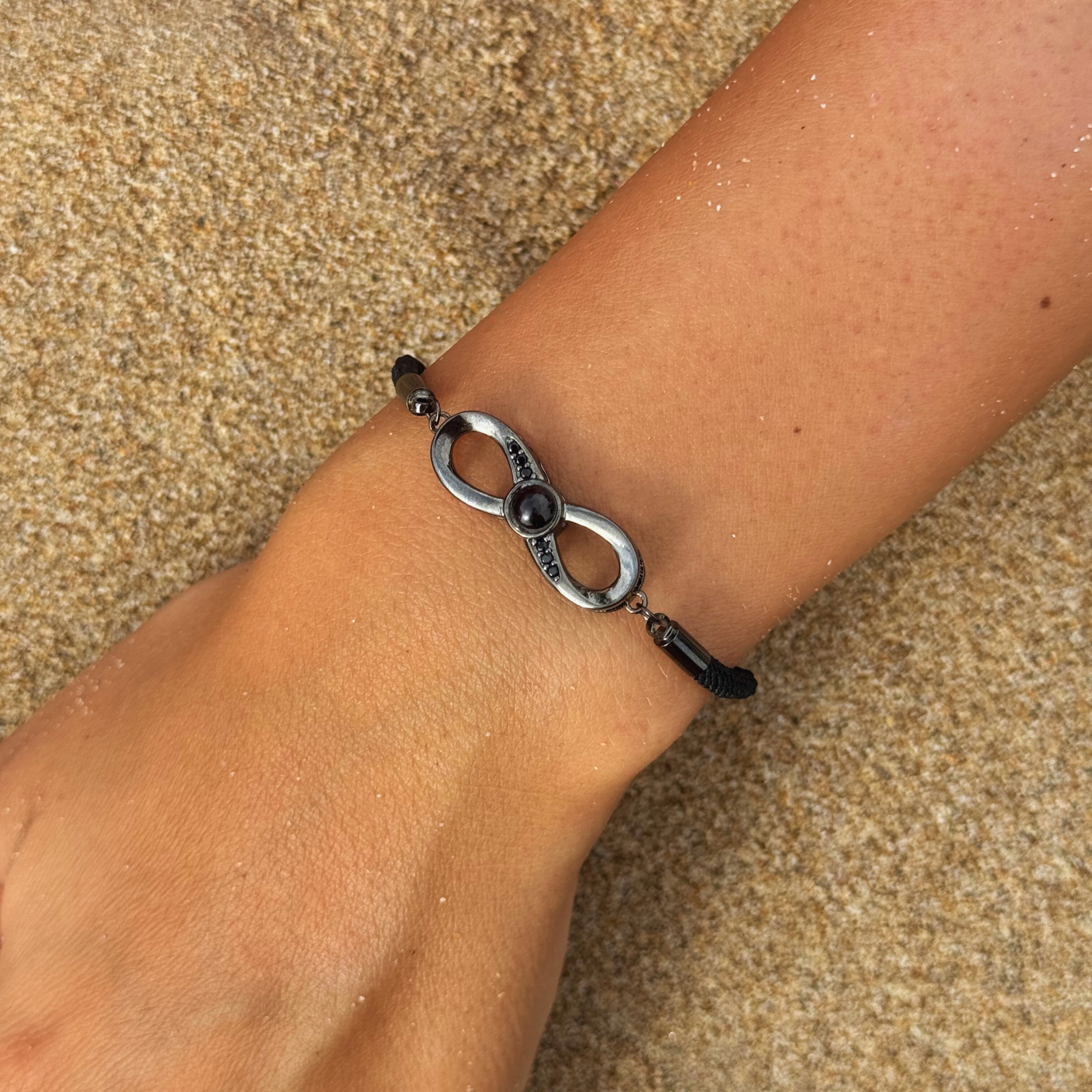 Bracelet Photo Personnalisé Valentin(e) - noir porté par une femme sur du sable